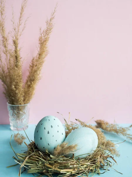 Uova di Pasqua in un nido d'erba. Sfondo rosa . — Foto Stock