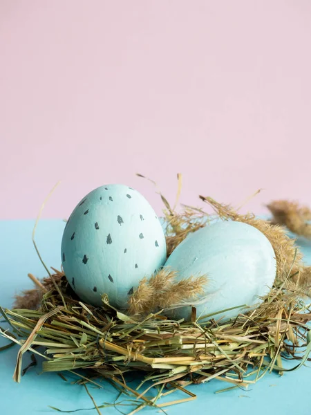Uova di Pasqua in un nido d'erba. Sfondo rosa . — Foto Stock