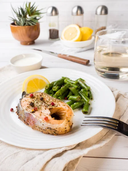 Здоровое питание. Запеченная красная рыба, розовый лосось, лосось и зеленая фасоль с ломтиком лимона на тарелке . — стоковое фото