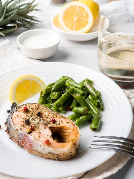 Здоровое питание. Запеченная красная рыба, розовый лосось, лосось и зеленая фасоль с ломтиком лимона на тарелке . — стоковое фото