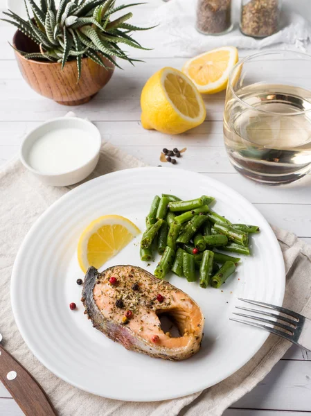 Sağlıklı gıda. Pişmiş kırmızı balık, Pembe somon, somon ve yeşil fasulye bir dilim limon bir plaka üzerinde.