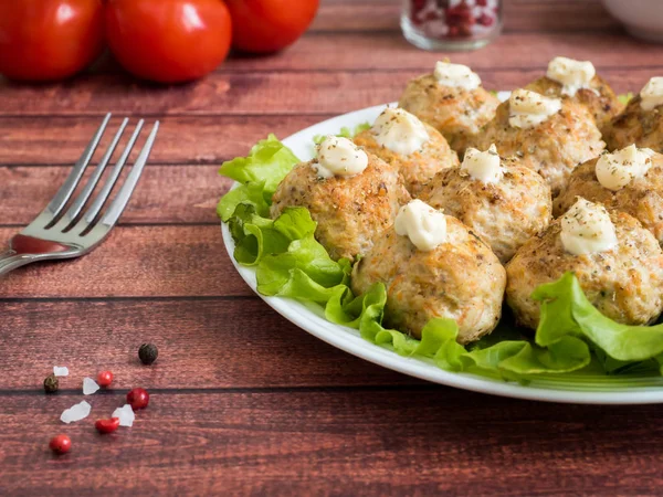 Läckra köttbullar med persilja, sallad och tomat närbild på en tallrik på bordet. horisontell — Stockfoto