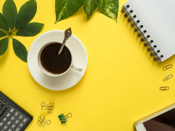 Negócios flat lay com espaço de cópia, calculadora, lápis, Bloco de notas, café sobre fundo amarelo colorido Plantas folhas verdes — Fotografia de Stock