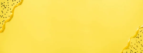 Banner yellow background with ribbons and confetti stars copy space.