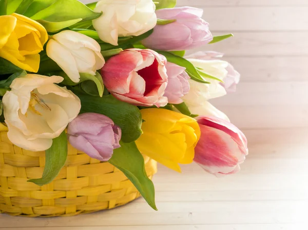 Ramo de tulipanes coloridos en una canasta de mimbre amarillo —  Fotos de Stock