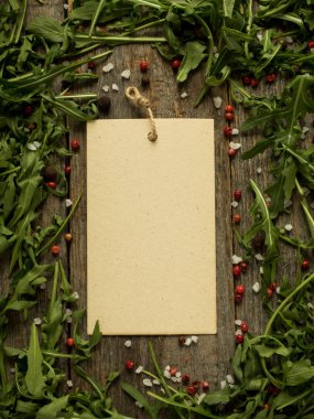 Roka, kırmızı ve siyah yaprakları ile ahşap arka plan üzerinde boş Not biber tuz kopya alanı