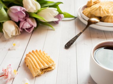 Bisküvi ve ahşap bir masa üzerinde Lale ile kahve fincanı