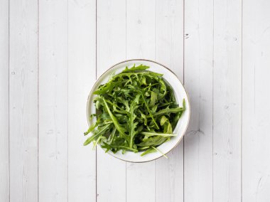 Plaka ve beyaz arka plan diyet salata roka yaprakları