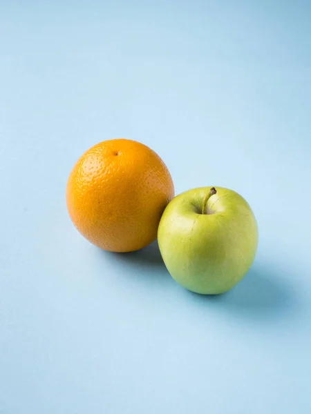 Φρέσκα φρούτα μήλο πορτοκάλι απομονώνονται σε μπλε φόντο — Φωτογραφία Αρχείου