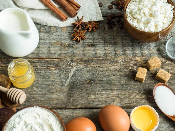 Cooking background with ingredients for making dough, cottage cheese, flour for baking, sugar and eggs on wooden rustic table, top view Copy space — Stock Photo, Image