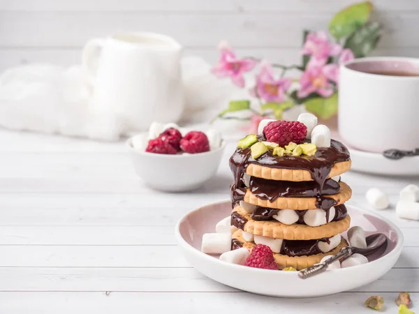 A sweet dessert of a chocolate cookie raspberry and marshmallow Cup of coffee on a light table. — Stock Photo, Image