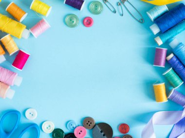 Düz yatıyordu çok renkli dikiş ipliği ve kopya alanı ile mavi arka plan düğmeleri