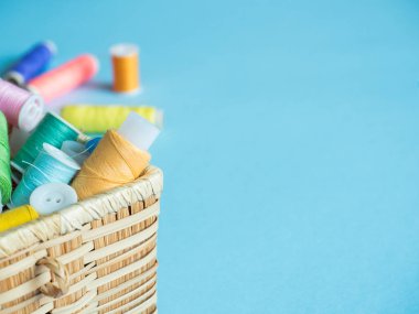 Renkli dikiş düğme ve bir ahşap kutu üzerinde mavi bir arka plan iş parçacığında.