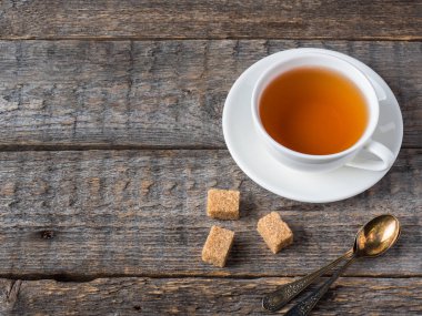 Beyaz çay Kupası ve fincan tabağı rustik ahşap arka plan kopya alanı üzerinde şeker kamışı kahverengi