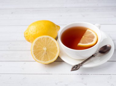 Bitkisel çay beyaz bir bardak taze limon Beyaz ahşap zemin üzerinde bir kavanoz bal