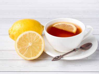 Bitkisel çay beyaz bir bardak taze limon Beyaz ahşap zemin üzerinde bir kavanoz bal