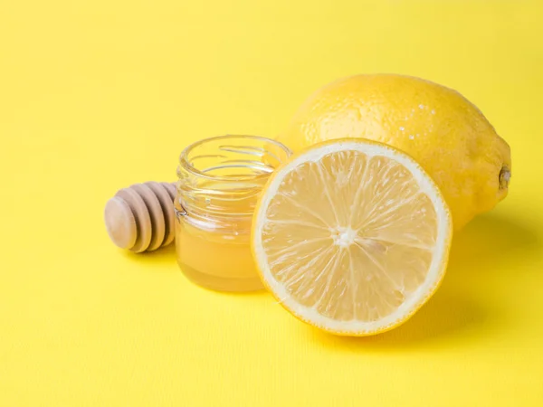 Банка меда и свежий лимон на ярко-желтом фоне — стоковое фото