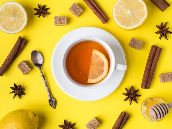 Flat lay on the yellow bright background Black tea Lemon Cinnamon Star Anise brown sugar jar of Honey Close up — Stock Photo, Image