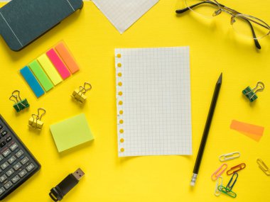 İş düz kopya alanı hesap makinesi ile kalem, not defteri, kahve gözlük renkli sarı zemin üzerinde yatıyordu.