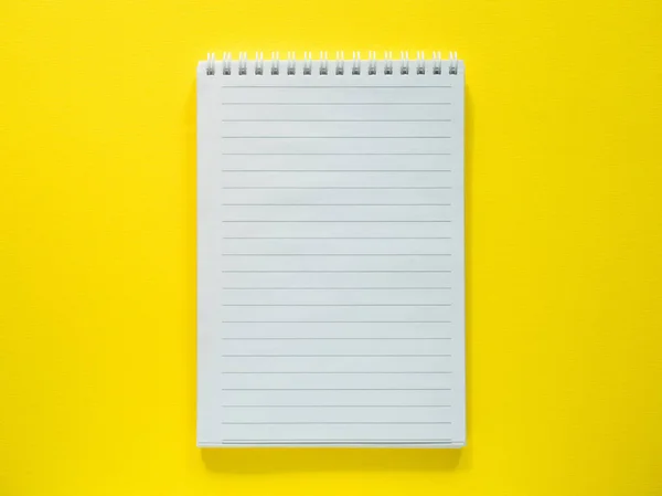 Blocco note per scrivere sul desktop giallo, flat lay, spazio di copia . — Foto Stock