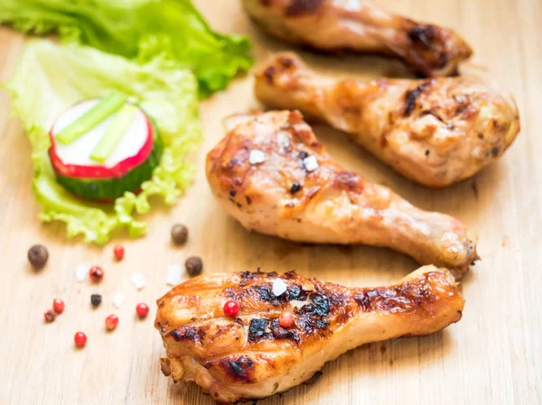 Grilled chicken drumsticks on a wooden Board with fresh vegetables Selective focus — Stock Photo, Image