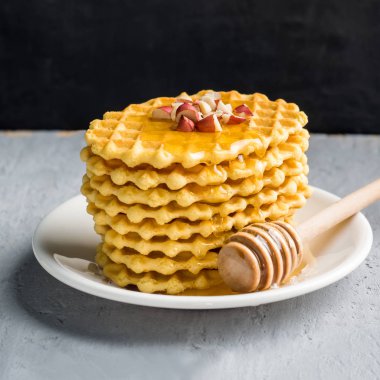 Gofret, desenli bisküvi ile bal ahududu ve fıstık bir gri arka plan siyah duvar ile drizzled