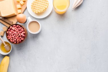 Sağlıklı kahvaltı peynir suyu kahve tatlım fıstık yumurta bisküvi waffle tahıl yulaf ezmesi elma muz. Seçici odak. Üstten Görünüm. Düz pozisyon