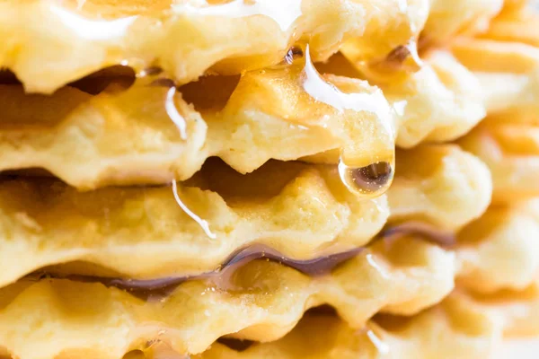 Bakgrund av våfflor, mönstrade cookies, beströs med honung och hallon. Selektivt fokus. — Stockfoto