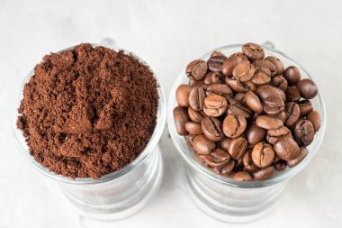 İki cam bardak kahve çekirdekleri ve hafif beton zemin üzerine çekilmiş kahve ile