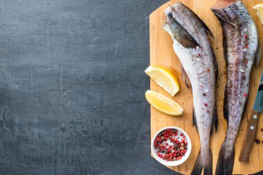 Köle çiğ balık üzerinde koyu arka plan limon tahtada ve biber karışımı ahşap kesim