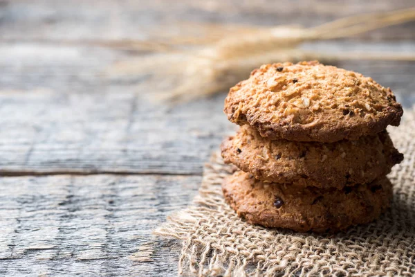 Oatmeal cereal cookies on napkin burlap wood table — Stock Photo, Image
