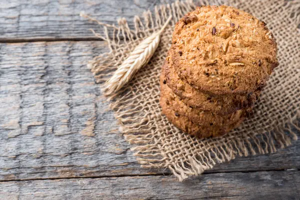 Oatmeal cereal cookies on napkin burlap wood table — Stock Photo, Image