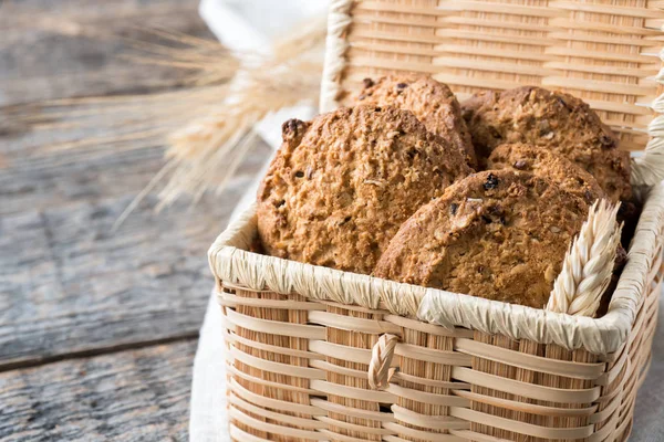 Oatmeal cereal cookies in wicker straw box wooden table — Stock Photo, Image