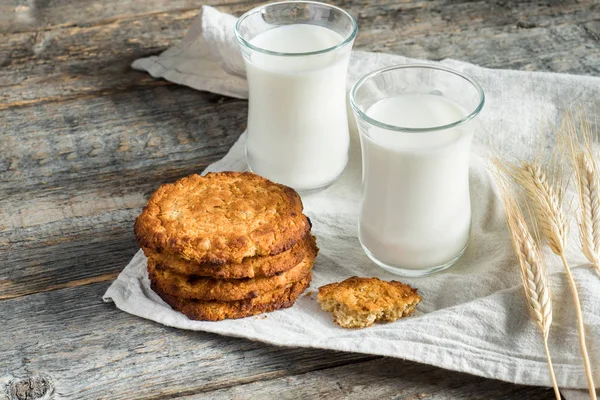 新鲜健康的牛奶和燕麦饼干与谷物在木质乡村背景 — 图库照片
