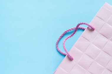 Hafif pembe Hediyelik çanta pastel mavi bir arka plan üzerinde.