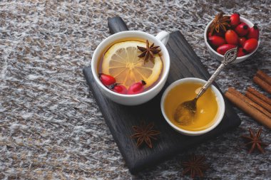 Limonlu ve ballı tarçınlı yabani gül böğürtlenlerinden iç. Gül kalçası vitamini takviyesi. Sıcak ev konsepti kış içeceği fotokopi alanı