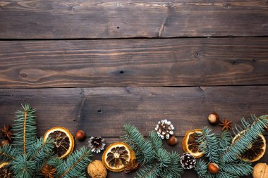 Noel ağacı konisi çerçevesi koyu ahşap arka planda fındık portakalı taşır. Uzayı kopyala Düz yatıyordu.