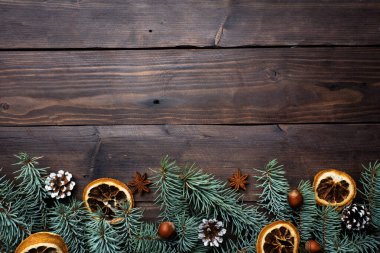 Noel ağacı konisi çerçevesi koyu ahşap arka planda fındık portakalı taşır. Uzayı kopyala Düz yatıyordu.