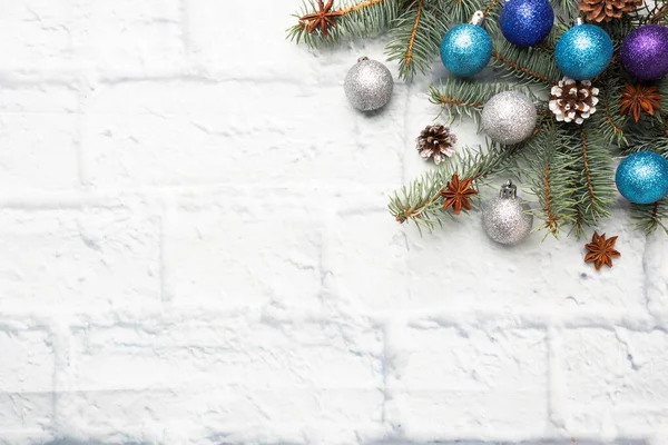 Kerst frame gemaakt van sparren, kerstboom decoraties in zilver en blauw op een lichte bakstenen achtergrond. Begrepen, ruimte. Vlakke plaat. — Stockfoto