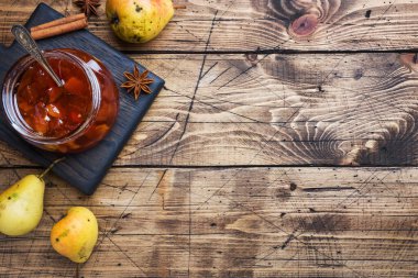 Kavanozda ev yapımı armut reçeli ve ahşap bir grupta taze armut.
