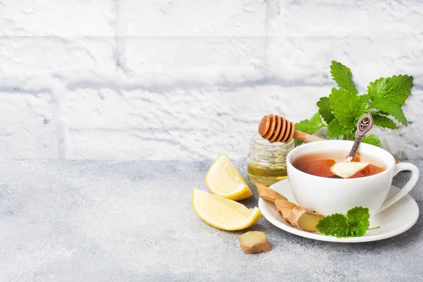 Λευκό Κύπελλο με φυσικό τσάι από βότανα και λεμόνι δυόσμο και μέλι. Γκρι φόντο χώρος αντιγραφής. — Φωτογραφία Αρχείου