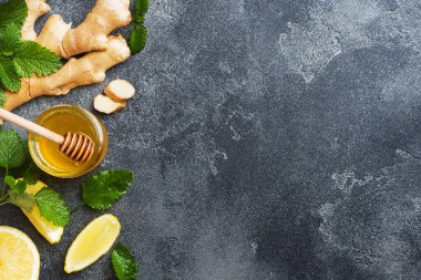 Koyu gri zemin üzerinde limon balı ve zencefil kökü kökü.