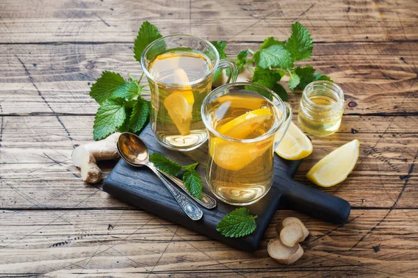 Zwei Tassen natürlichen Kräutertee Ingwer Zitronenminze und Honig auf einem hölzernen Hintergrund. Kopierraum — Stockfoto