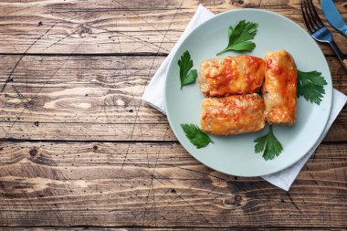 Tabakta sığır eti, pirinç ve sebzeli lahana ruloları. Lahana dolması ve et. Ahşap arkaplan Kopyalama alanı.
