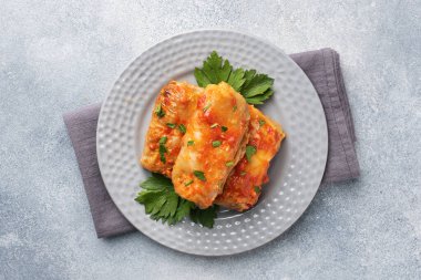 Tabakta sığır eti, pirinç ve sebzeli lahana ruloları. Lahana dolması ve et. Gri beton tablo Boşluğu kopyala.