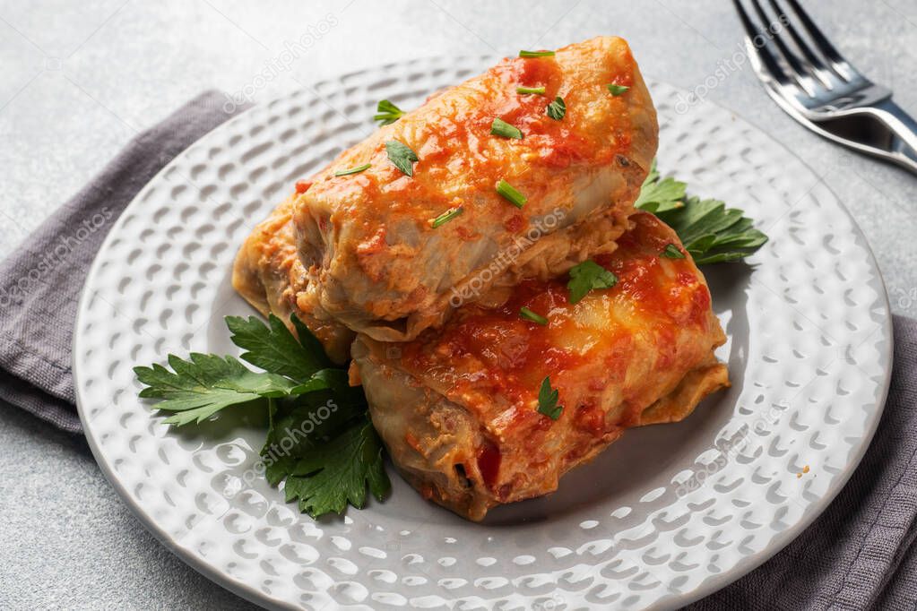 Cabbage rolls with beef, rice and vegetables on the plate. Stuffed cabbage leaves with meat. Gray concrete table