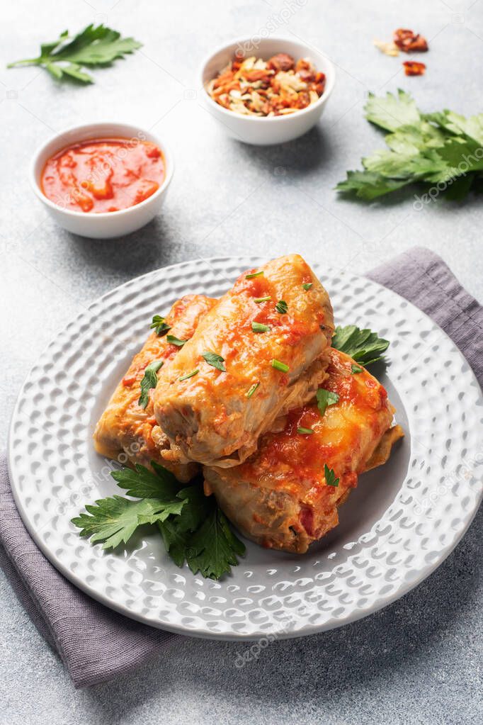 Cabbage rolls with beef, rice and vegetables on the plate. Stuffed cabbage leaves with meat. Gray concrete table