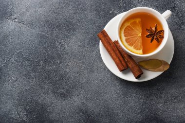 Limon tarçın ile doğal bitkisel çay ile Beyaz Fincan. Sıcak vitaminli içecek soğuk algınlığı için kullanılır. Koyu beton arka plan kopyalama alanı.