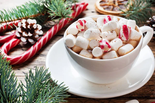 Une tasse de chocolat chaud avec des guimauves. Arbre de Noël et décorations, caramel de canne et oranges noix Fond en bois — Photo
