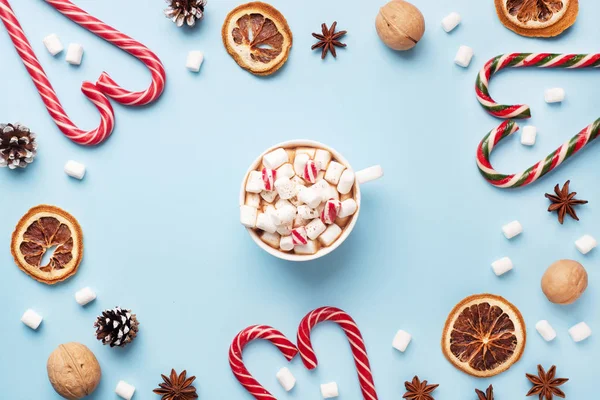Šálek horké čokolády s marshmallow kakaový prášek a karamelové ořechy, pomeranče na pastelové modré pozadí s kopírovacím prostorem. Vánoční zimní koncept. — Stock fotografie